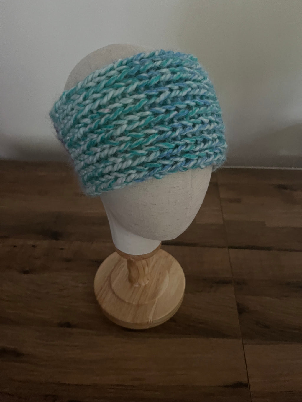 Handmade knitted angora blend ear warmer in a variegated pastel rainbow colour