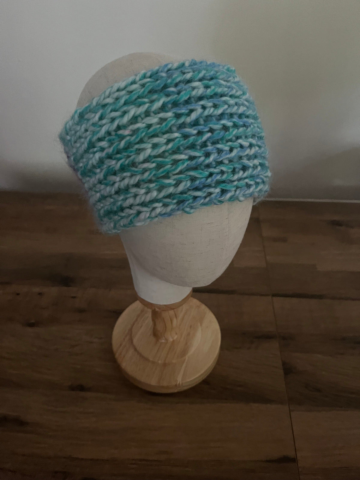Handmade knitted angora blend ear warmer in a variegated pastel rainbow colour