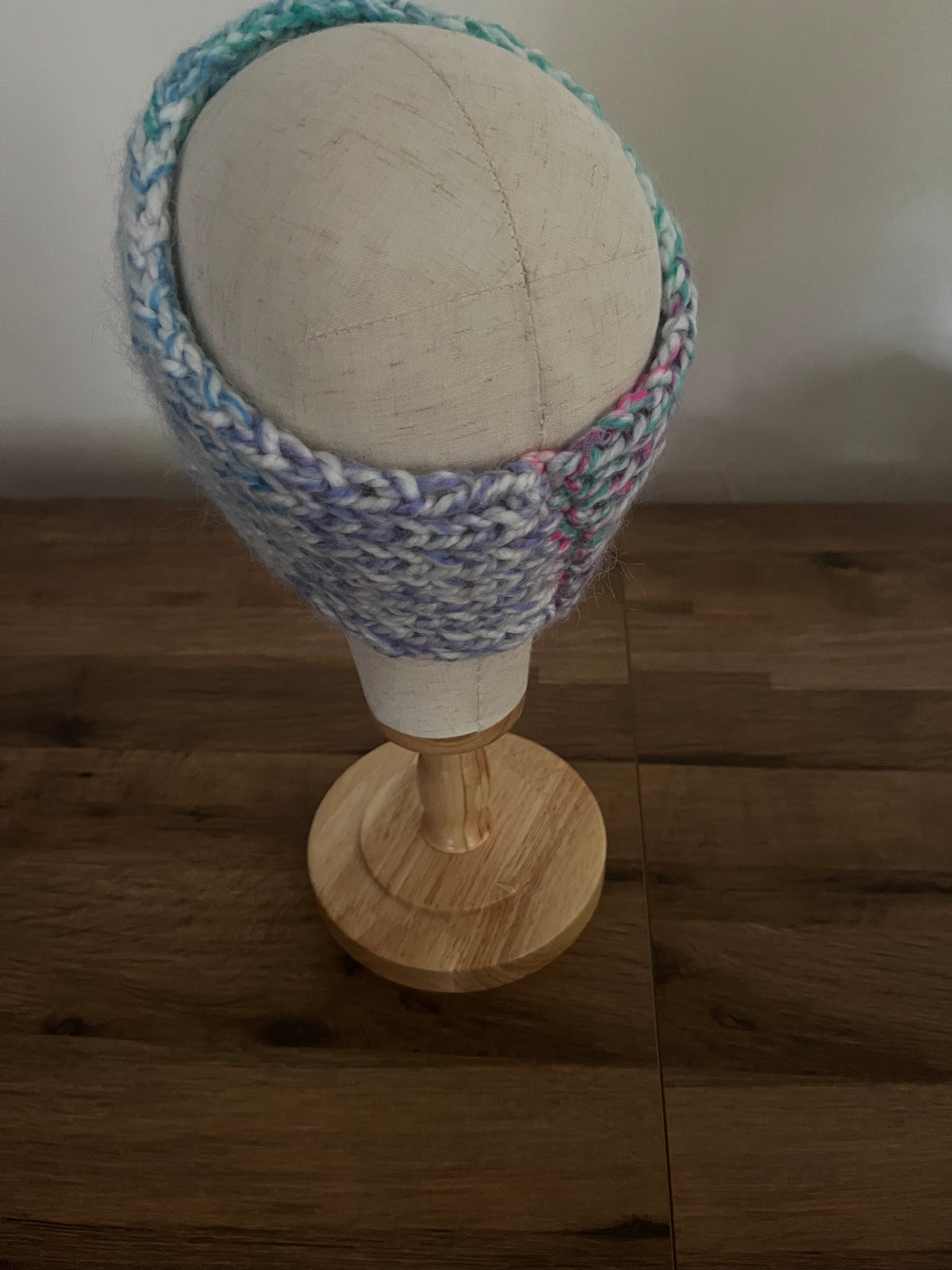 Handmade knitted angora blend ear warmer in a variegated pastel rainbow colour