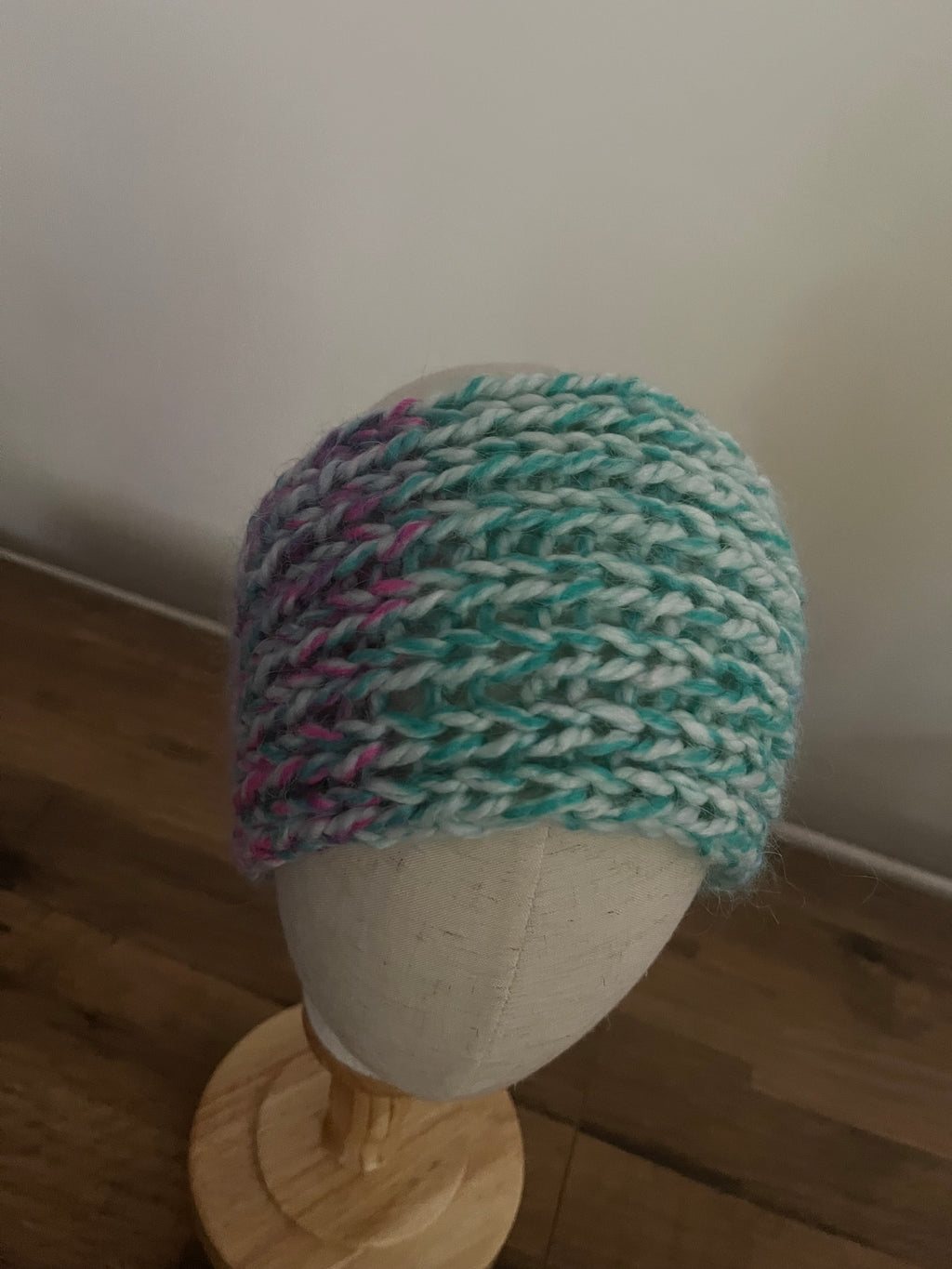 Handmade knitted angora blend ear warmer in a variegated pastel rainbow colour