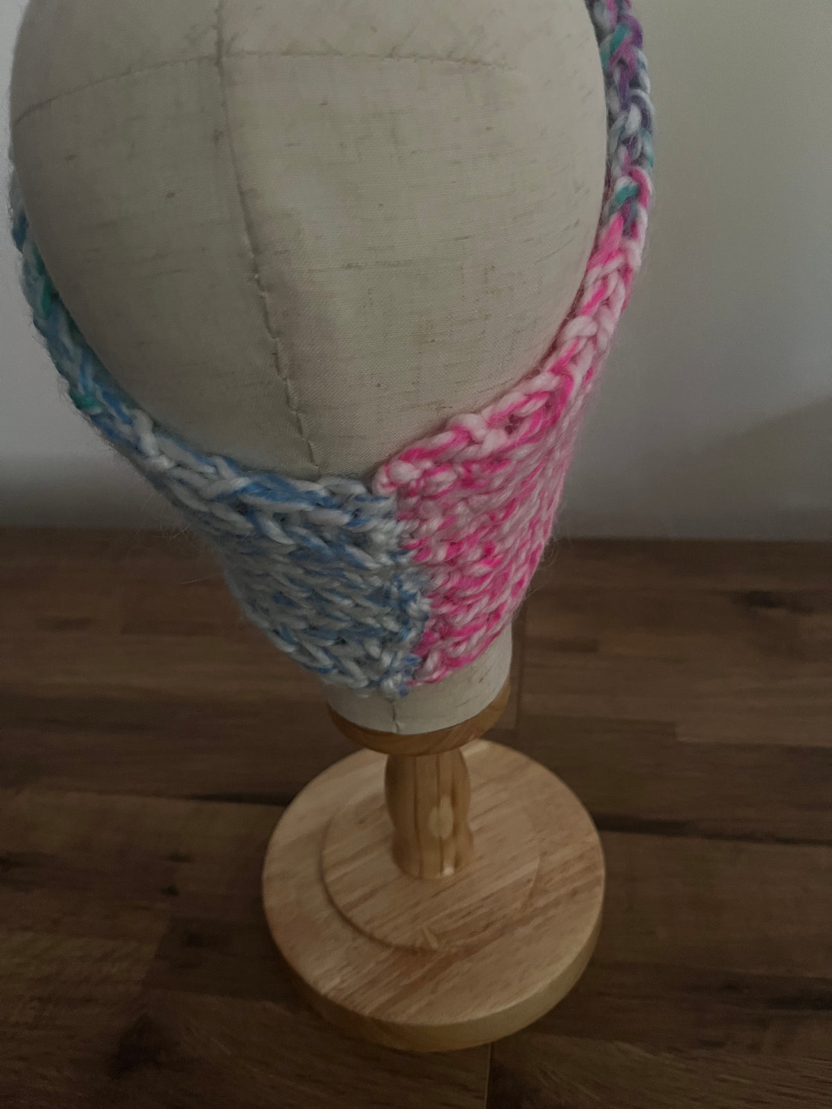 Handmade knitted angora blend ear warmer in a variegated pastel rainbow colour