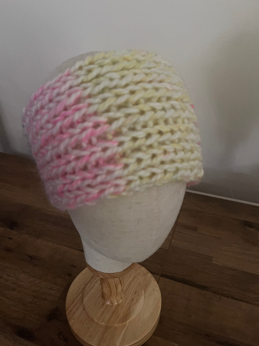 Handmade knitted angora blend ear warmer in a variegated pastel rainbow colour