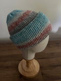 Hand made knitted beanie hat in a blue, grey and coral colour