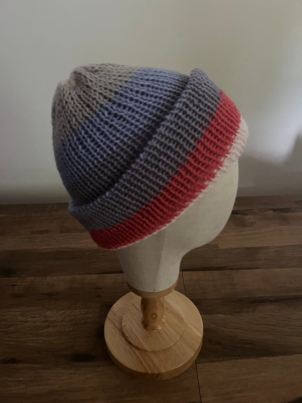Hand made knitted reversible beanie hat in a variegated blue, grey and red