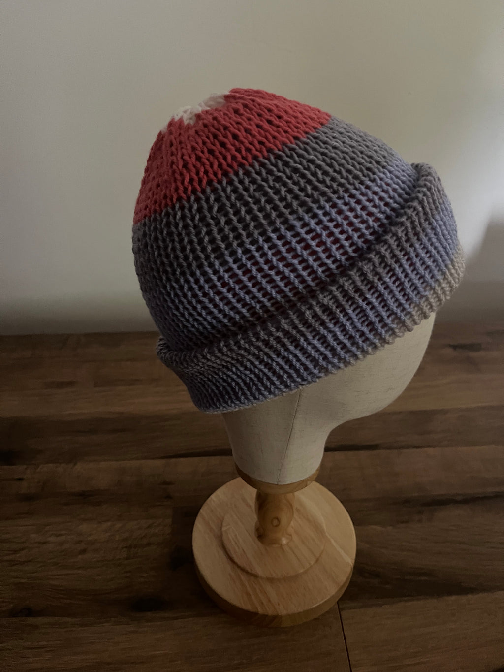 Hand made knitted reversible beanie hat in a variegated blue, grey and red