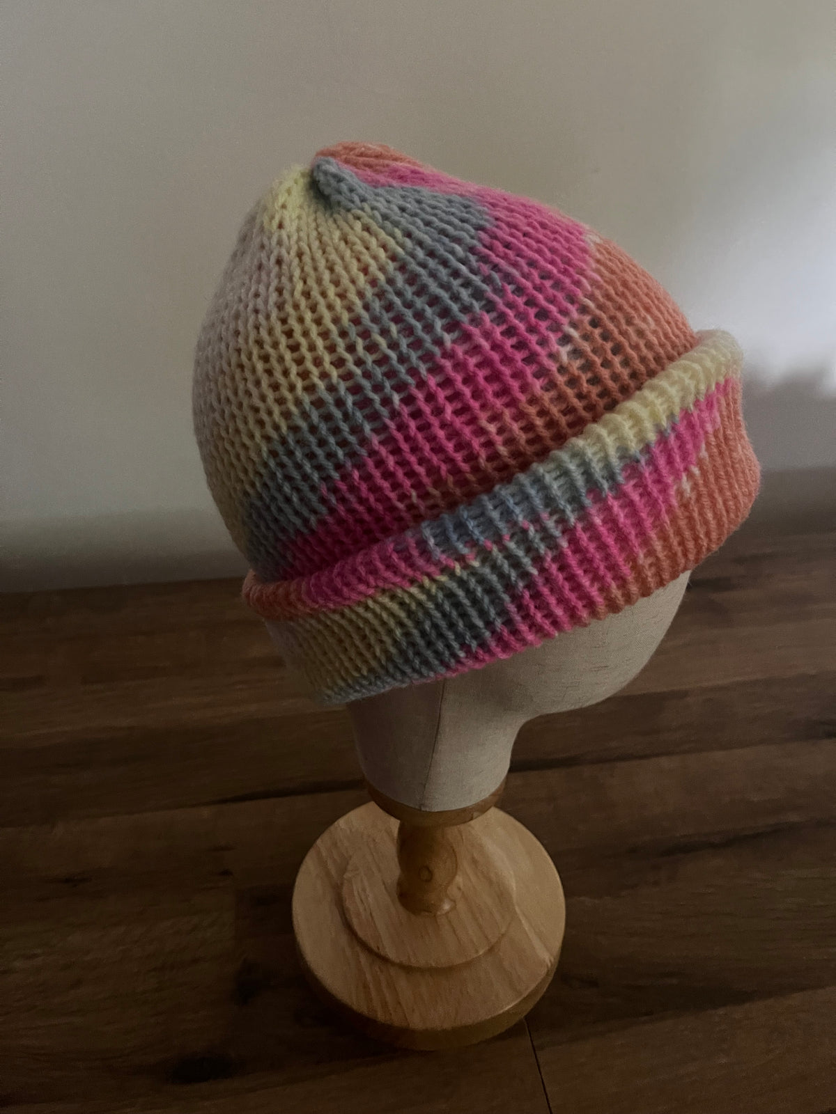 Hand made knitted reversible beanie in a bright pastel rainbow variegated colour