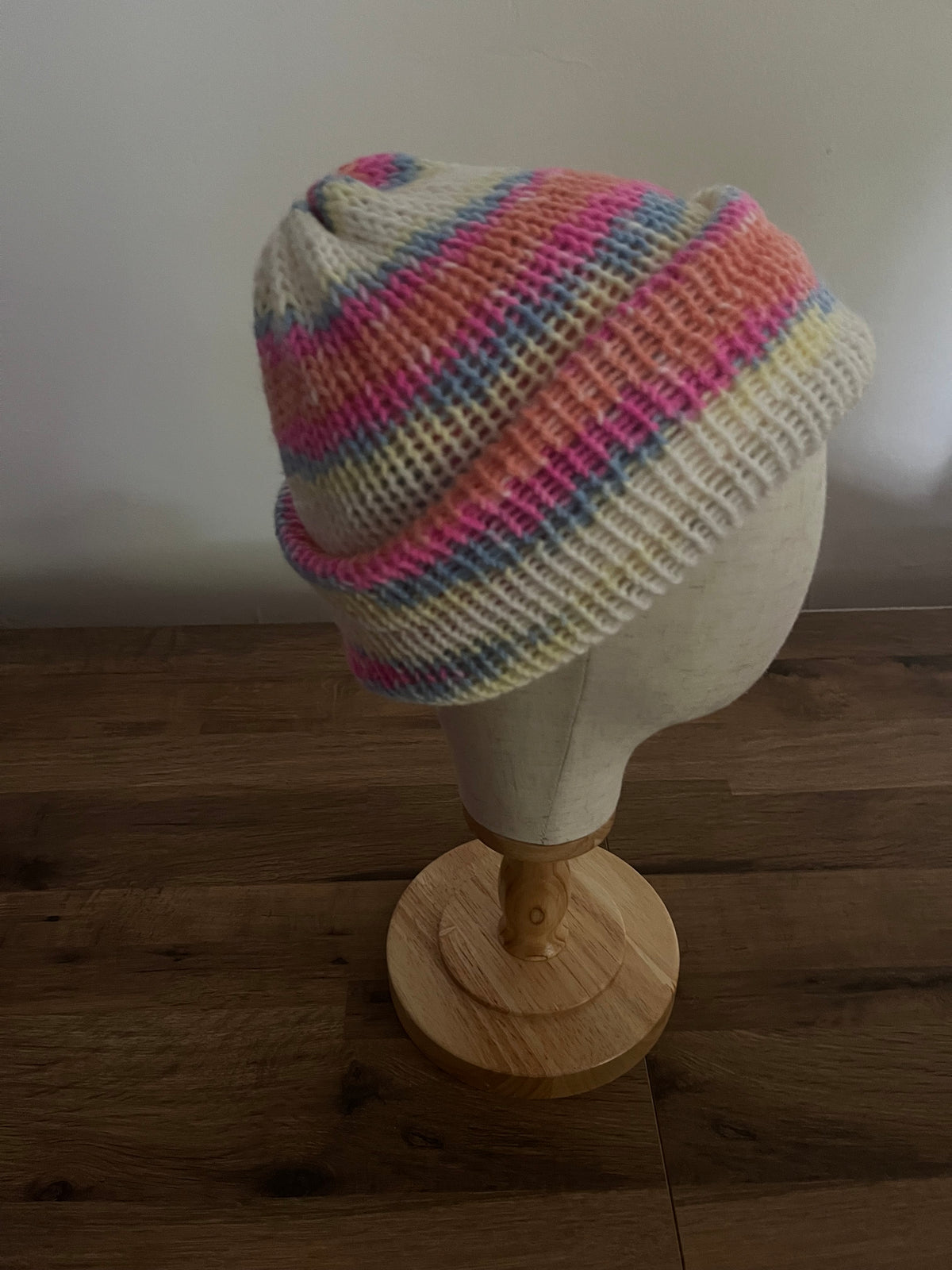 Hand made knitted reversible beanie in a bright pastel rainbow variegated colour