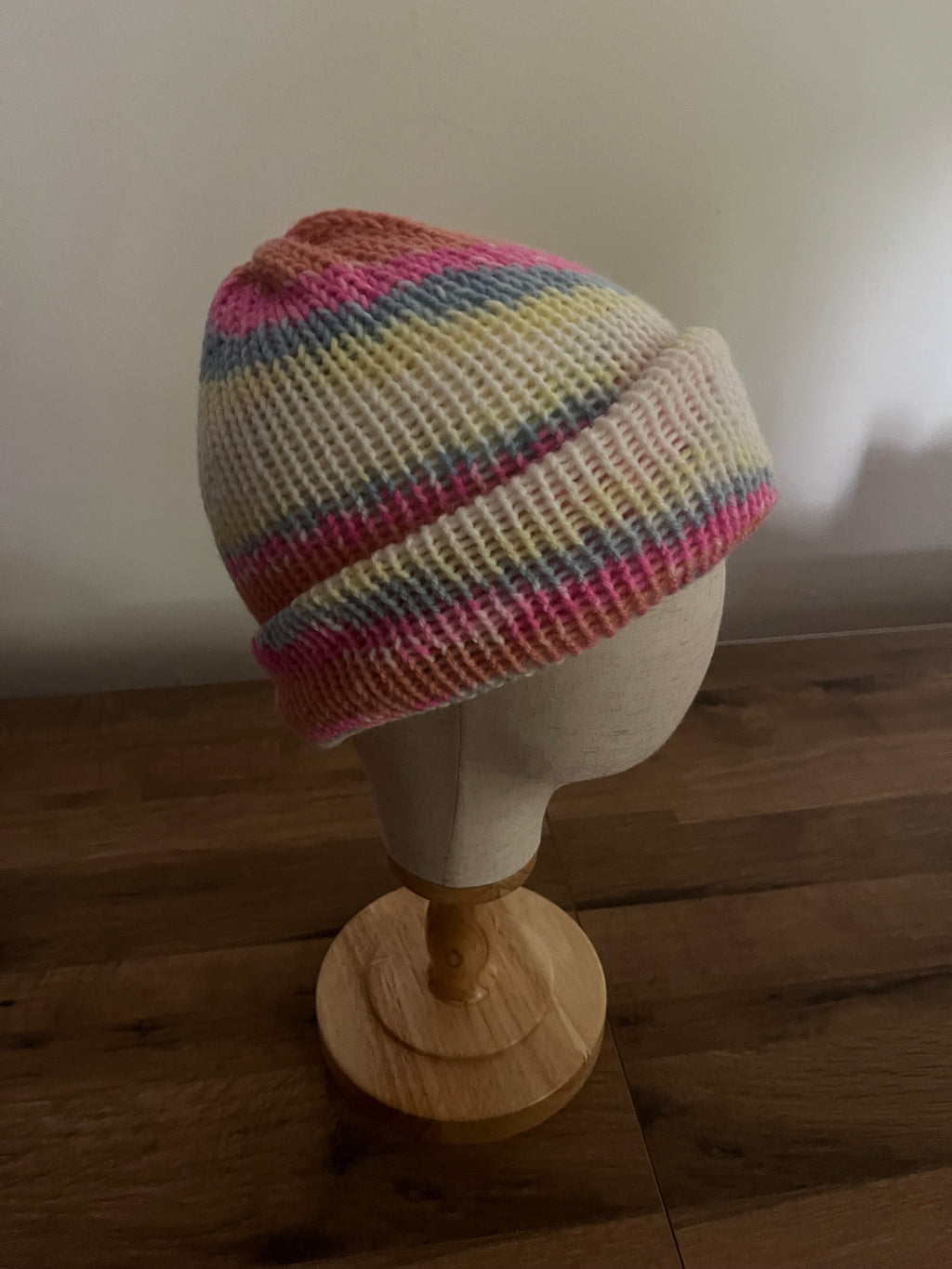 Hand made knitted reversible beanie in a bright pastel rainbow variegated colour